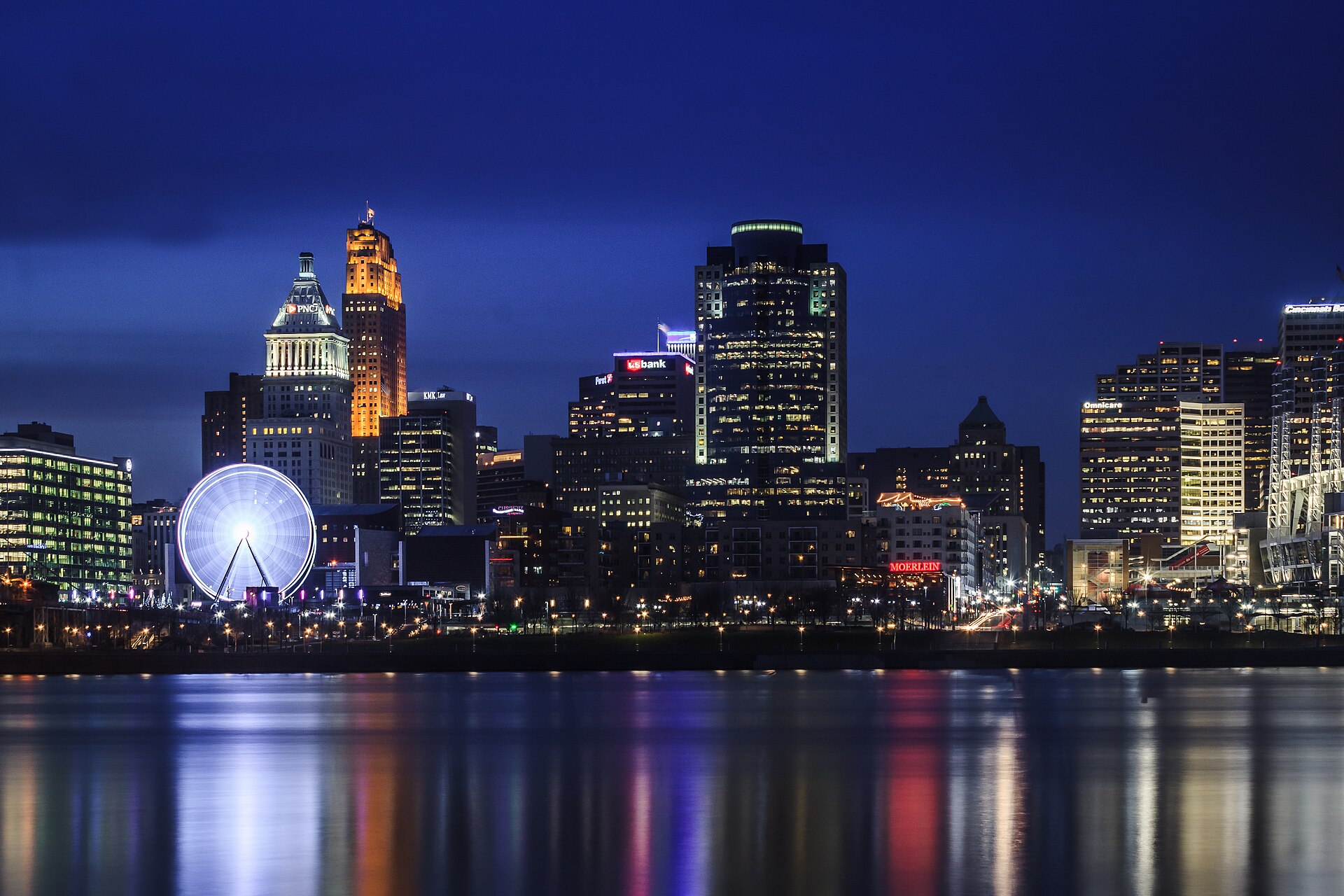 Downtown Cincinnati skyline in blue-hour twilight, seen from across the Ohio River